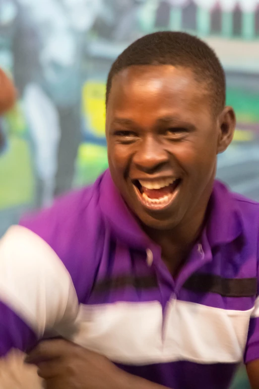 a man with a laughing face wearing purple