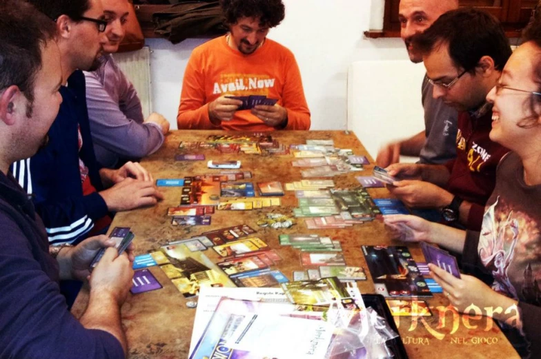 a group of people are sitting at a table playing games