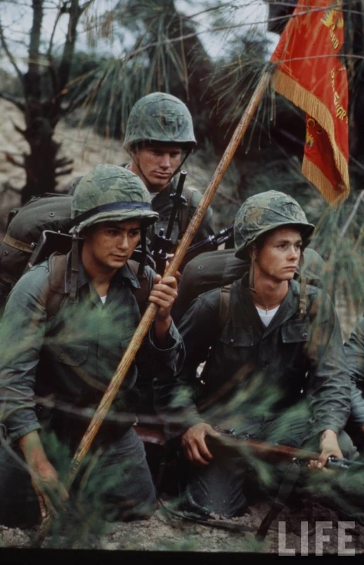 soldiers with helmets holding flags looking in opposite directions