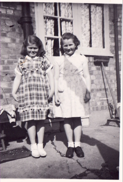 two girls are wearing dress and holding a bag