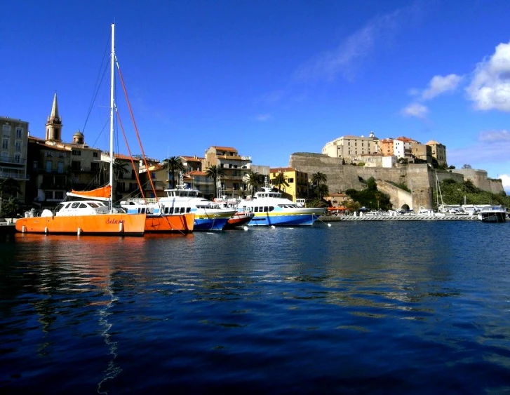 some boats in a large body of water near buildings and a castle