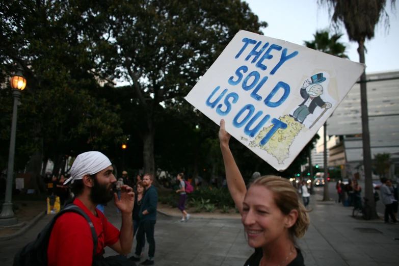 people standing on a sidewalk holding up signs