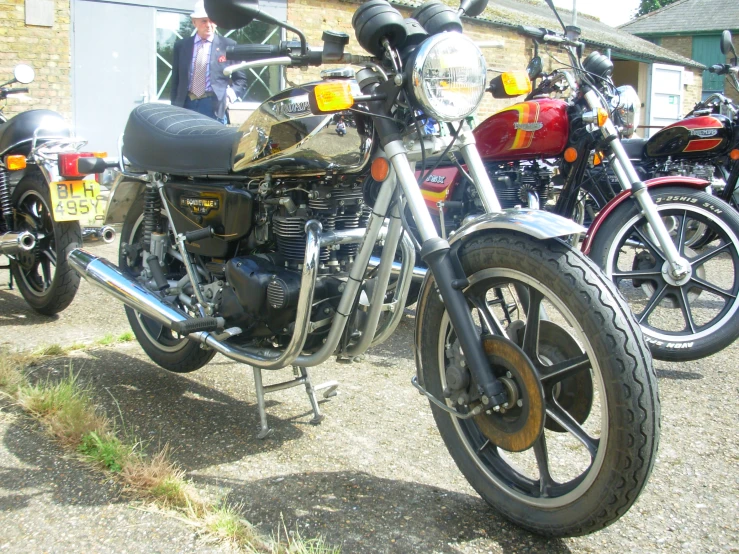 a number of motorcycles parked on a gravel road