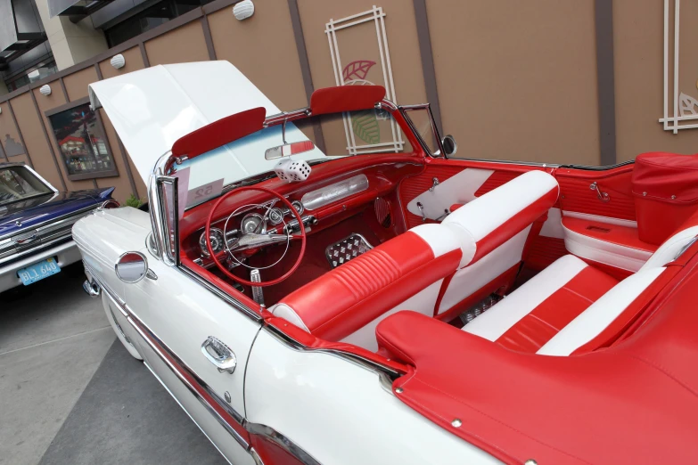 a classic red and white car with its hood down