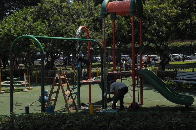 a person on a bike standing in front of a play structure