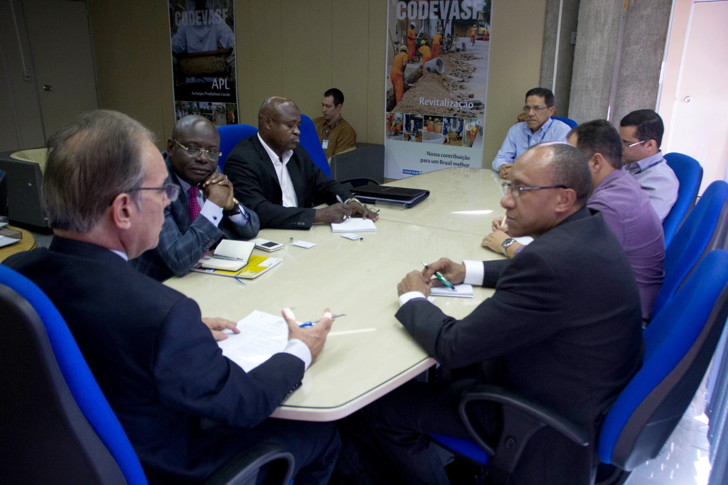 a group of men sitting around a table discussing