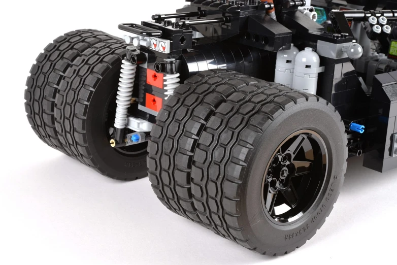 a lego batman car with a small truck underneath it