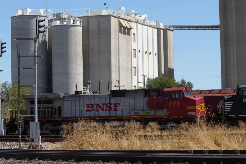 a large grain silos next to a train on a track