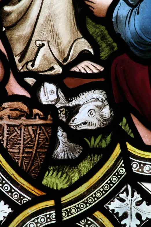 a stain glass depicts three people in the grass, with a woman sitting in front of them and holding a basket