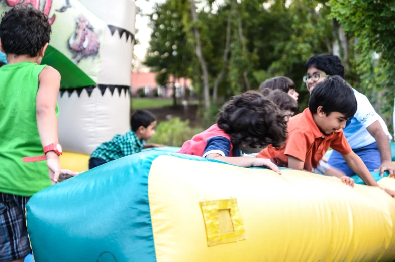 there are children playing on an inflatable object