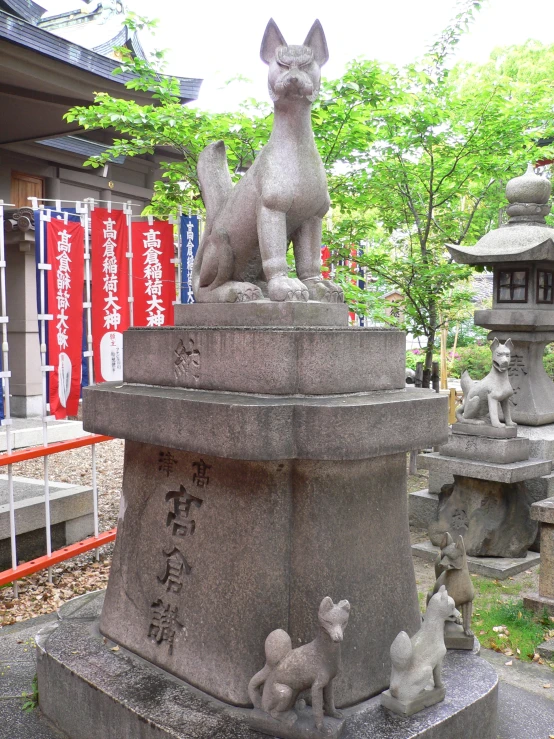 an ornately carved and cement dog monument at a buddhist garden