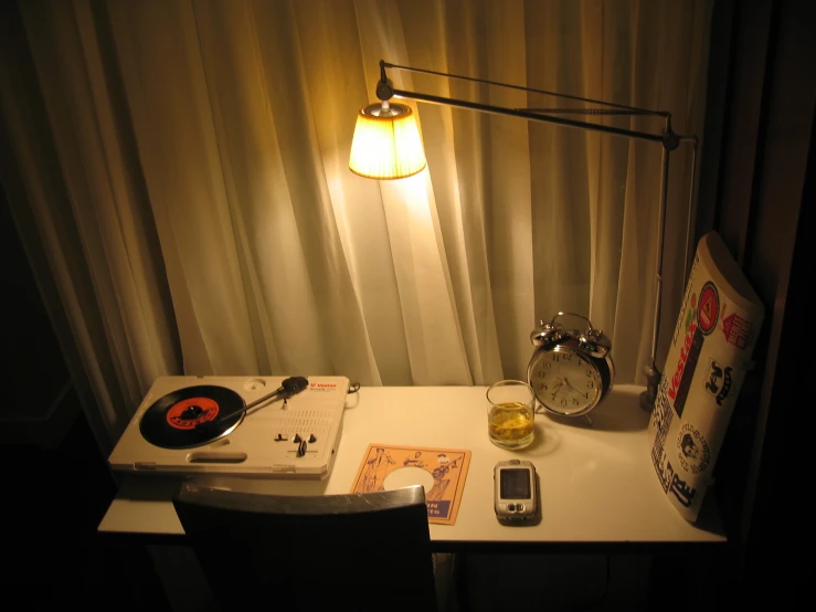 a table with a clock, alarm, and record player