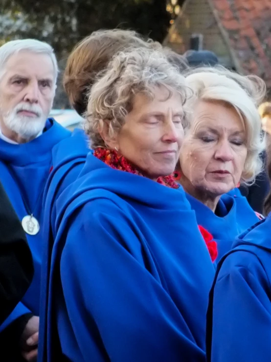 people standing in the street with their hands behind their backs