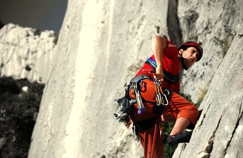 the man is climbing up the rock formation