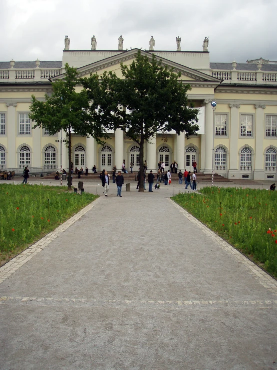 a big building with a large green tree on the sidewalk