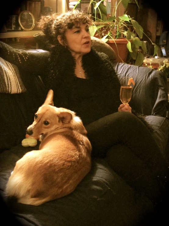 a woman sitting on a couch with a dog