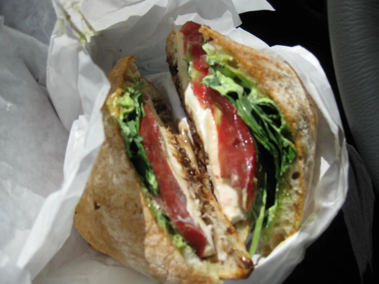 a sandwich with lettuce and tomatoes sitting in it's side dish