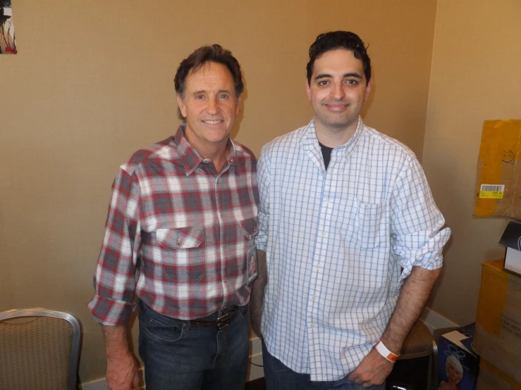 two men standing next to each other in an office