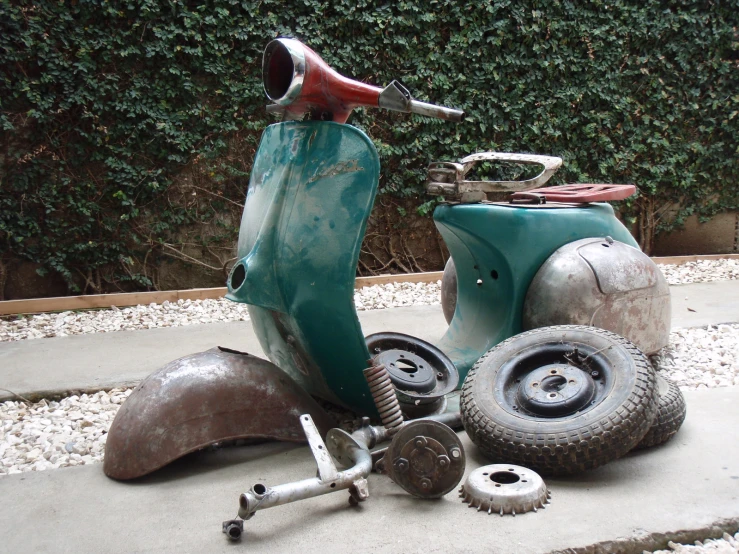 there is an old scooter and two smaller wheels