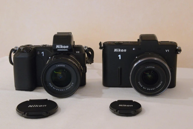 three nikon digital cameras with an accessory placed at the front