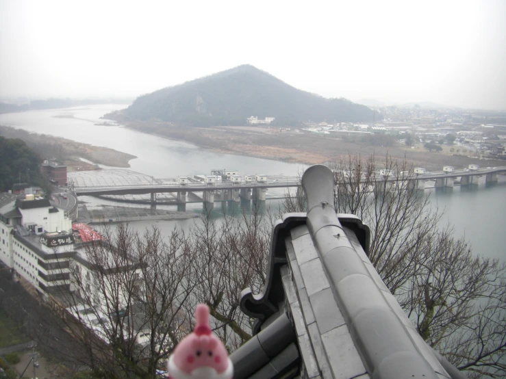 a view from an observation point of a bridge over a river and mountains