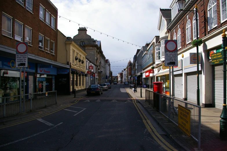 an empty street with shops on the side and stores