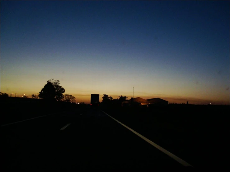 a truck driving down the street under a blue sky