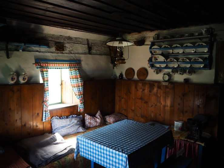 the room has wood paneled walls, wood flooring, and a table in it