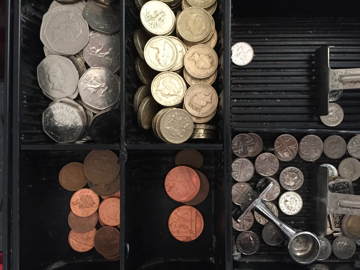 a bunch of different types of coins in various boxes