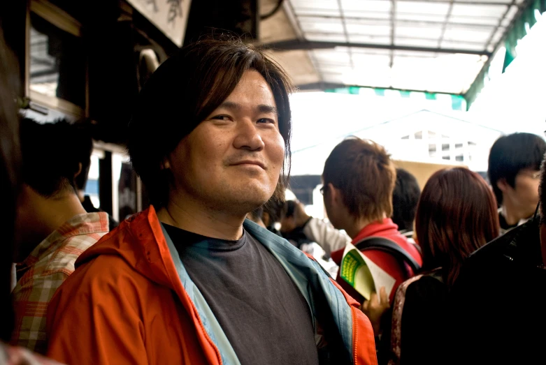 asian man standing in front of a crowd