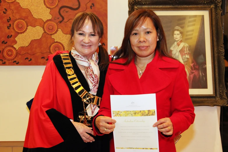 two women holding up a signed paper in their hands