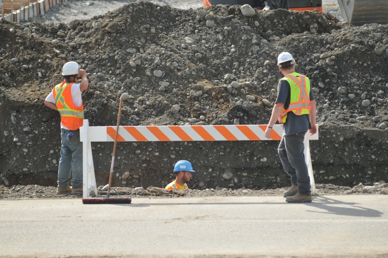 a bunch of construction workers standing by some dirt