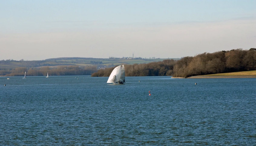 a sail boat sails across the water