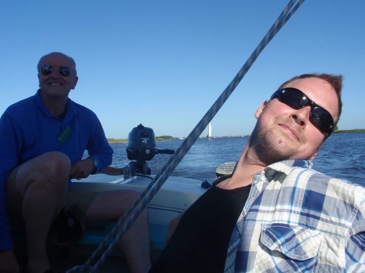 a man sitting in the back of a boat with another guy