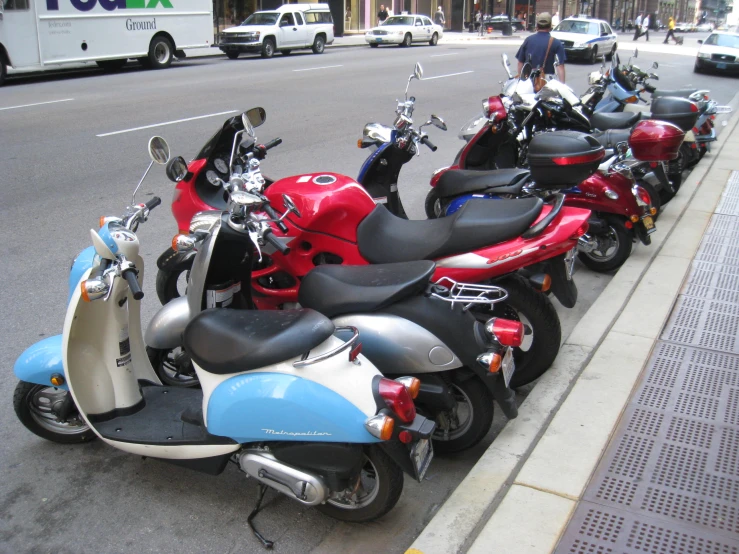 the motorcycles are lined up along the sidewalk