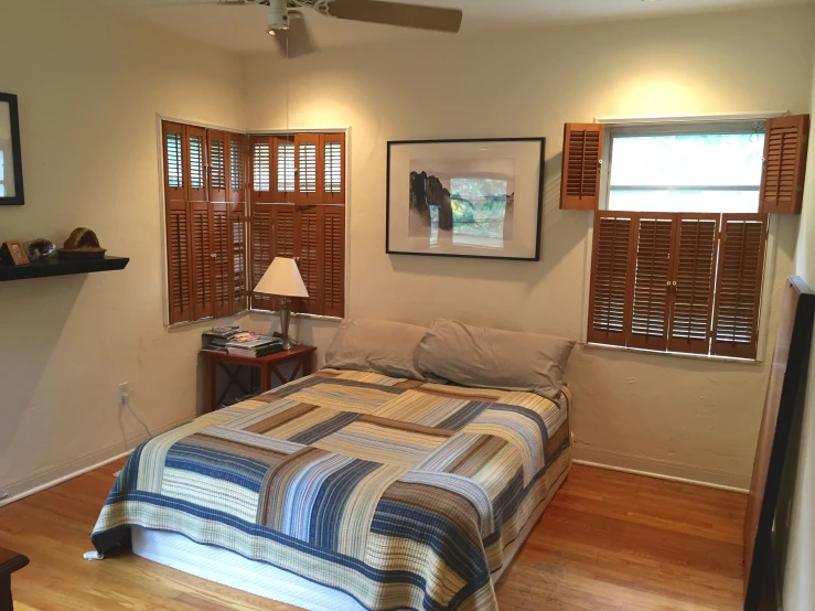 an empty bedroom with a double bed and wood floor