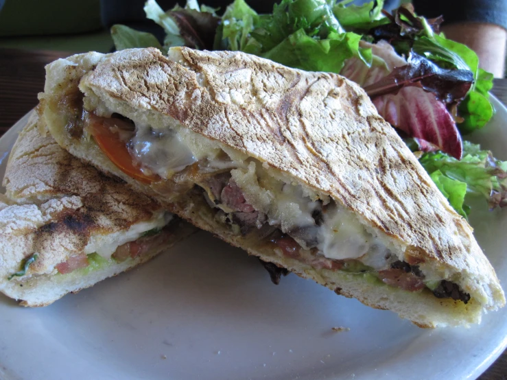 a plate has a sandwich on it next to a salad