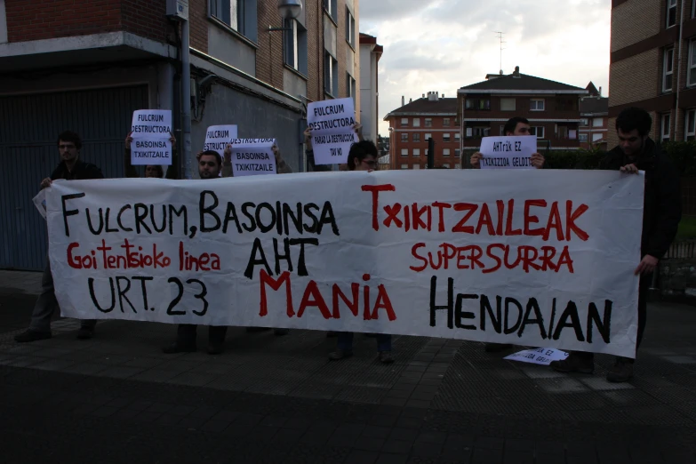 many people holding protest signs in an urban area