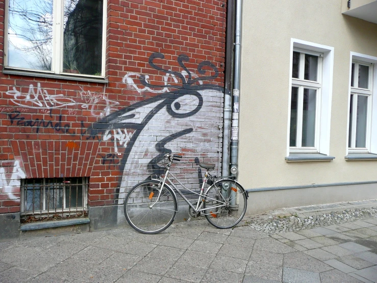 a bike is leaning against a wall with graffiti on it
