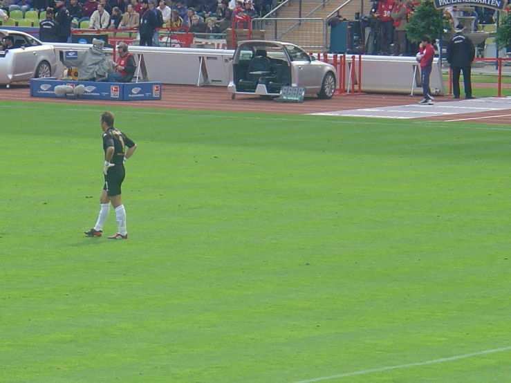 a soccer player on a field looking down at his knees