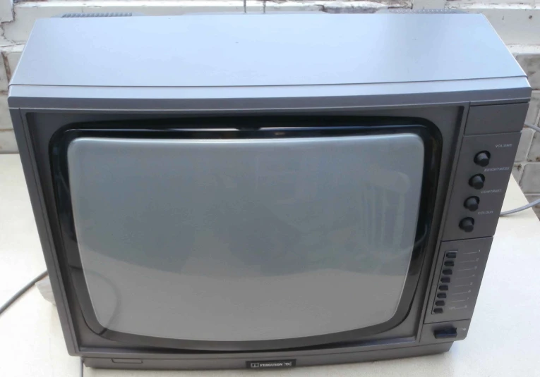 an old television turned on with the screen still attached