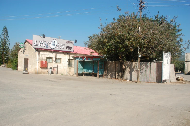 an old run down business with sign next to it