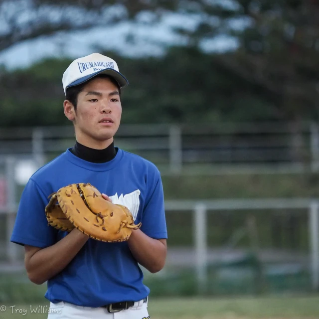 a person in a blue shirt is holding a baseball