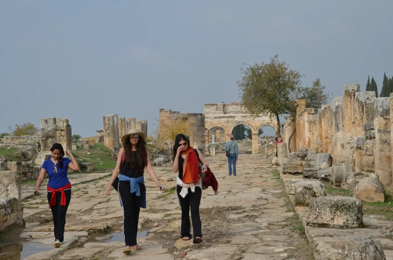 three women walk across an area covered with stone and boulders