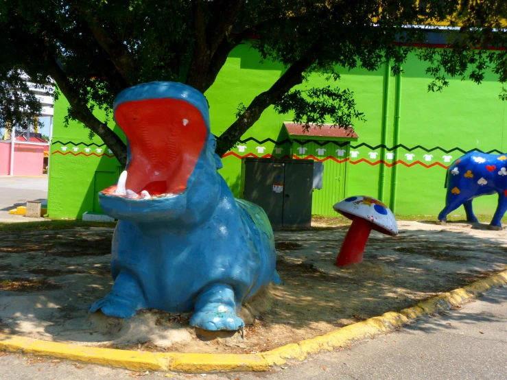 children's sculptures on the ground in front of a green wall