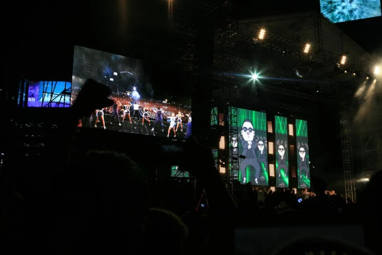 a stage with large green and white pictures of rock stars