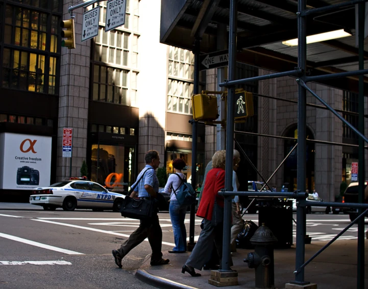 people walking across the street near construction on the street