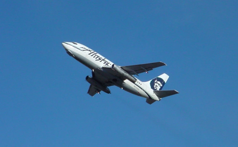 an airplane flying overhead in the blue sky