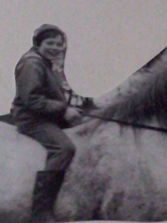a black and white po of a person sitting on a horse