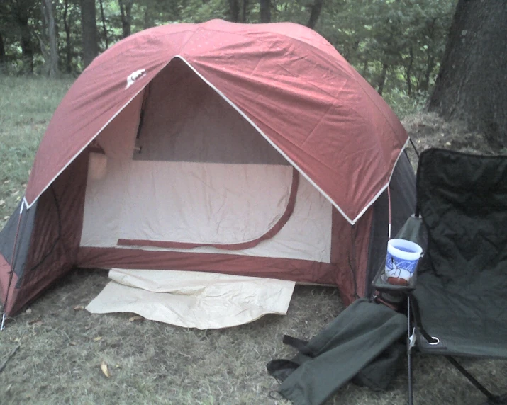 two tents are in the woods with a blanket